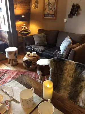 a living room with a couch and a table with a candle at Duplex en vieux bois hyper centre in Chamonix-Mont-Blanc