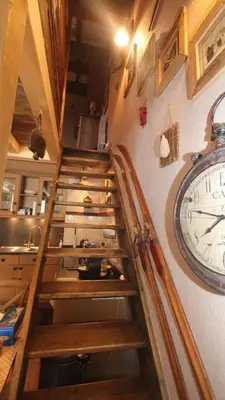 a spiral staircase with a clock on a wall at Duplex en vieux bois hyper centre in Chamonix-Mont-Blanc