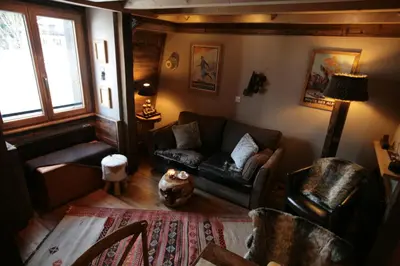 a living room with a couch and a chair at Duplex en vieux bois hyper centre in Chamonix-Mont-Blanc