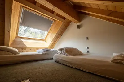 two beds in a room with a window at Vert Lodge Chamonix in Chamonix-Mont-Blanc