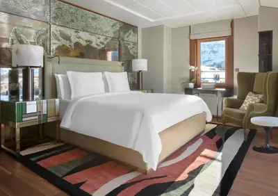 a bedroom with a large white bed and a chair at Four Seasons Resort Megève in Megève