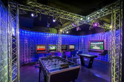 a room filled with ping pong tables and televisions at Four Seasons Resort Megève in Megève