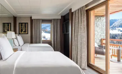 a hotel room with two beds and a balcony at Four Seasons Resort Megève in Megève
