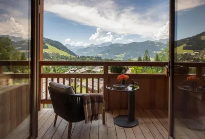 a balcony with a table and chairs and a view at Four Seasons Resort Megève in Megève