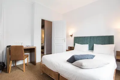 a bedroom with a bed with a desk and a chair at Hotel Les Lanchers in Chamonix-Mont-Blanc