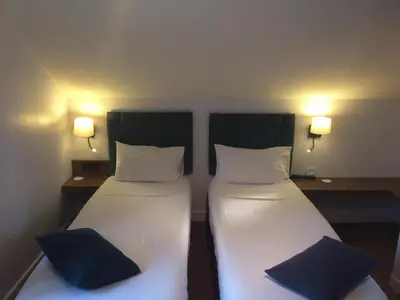 two beds in a room with lights on the wall at Hotel Les Lanchers in Chamonix-Mont-Blanc