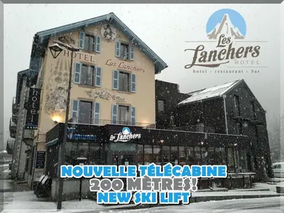 a building in the snow with a sign in front of it at Hotel Les Lanchers in Chamonix-Mont-Blanc