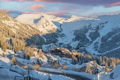 a bed in a room with a large window at Dormio Resort Les Portes du Grand Massif in Flaine