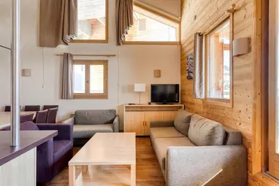 a living room with a couch and a table at Dormio Resort Les Portes du Grand Massif in Flaine