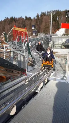 two people riding a toy train on a roller coaster at résidence Le Platé in Les Carroz d'Araches