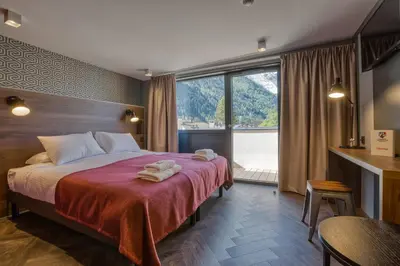 a hotel room with a bed with towels on it at Pointe Isabelle in Chamonix-Mont-Blanc