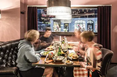 a group of people sitting around a table in a restaurant at Pointe Isabelle in Chamonix-Mont-Blanc