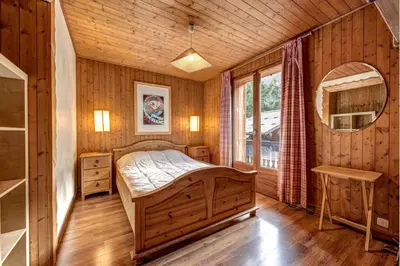 a bedroom with a bed in a wooden room at Chalet Les Frenes in Chamonix-Mont-Blanc
