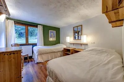 a bedroom with two beds and a window at Chalet Les Frenes in Chamonix-Mont-Blanc
