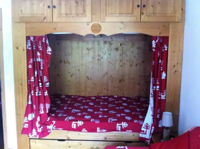 a bed with a red canopy in a room at Studio d'Anaite in Les Houches