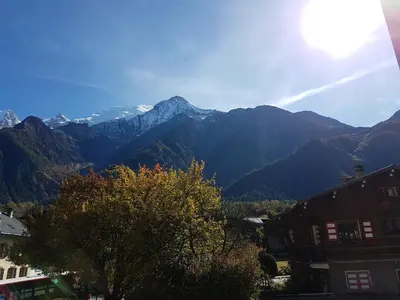a view of a mountain range with a tree and buildings at Studio d'Anaite in Les Houches