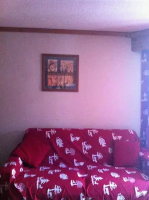 a red couch with a blanket on top of it at Studio d'Anaite in Les Houches