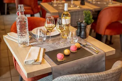 a table with glasses of wine and food on it at Les Loges Blanches Megève in Megève