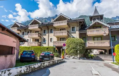 a large building with cars parked in front of it at Residence La Ginabelle - maeva Home in Chamonix-Mont-Blanc