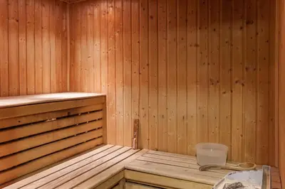 a wooden sauna with a glass table in it at Residence La Ginabelle - maeva Home in Chamonix-Mont-Blanc
