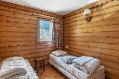 a bedroom with two beds in a log cabin at Residence La Ginabelle - maeva Home in Chamonix-Mont-Blanc