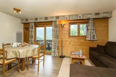 a living room with a table and a couch at APARTMENT REFUGE DE BELLACHAT - Alpes Travel - Les Houches - Sleeps 4 in Les Houches