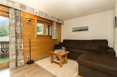 a living room with a couch and a table at APARTMENT REFUGE DE BELLACHAT - Alpes Travel - Les Houches - Sleeps 4 in Les Houches