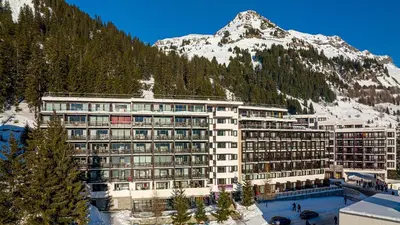 a large building with a mountain in the background at Madame Vacances Les Terrasses De Véret in Flaine