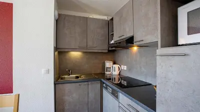 a kitchen with stainless steel cabinets and a sink at Madame Vacances Les Terrasses De Véret in Flaine