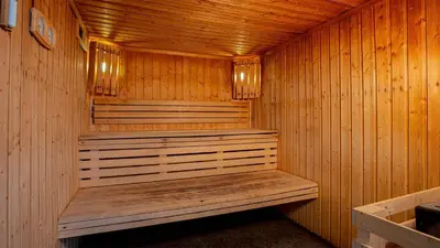 a wooden sauna with a wooden bench in it at Madame Vacances Les Terrasses De Véret in Flaine
