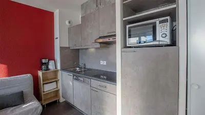 a small kitchen with a sink and a microwave at Madame Vacances Les Terrasses De Véret in Flaine