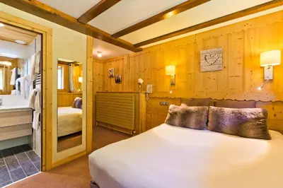 a bedroom with a bed and a bathroom at Aiguille du Midi - Hôtel & Restaurant in Chamonix-Mont-Blanc