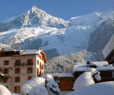 a snow covered mountain in front of a building at Aiguille du Midi - Hôtel & Restaurant in Chamonix-Mont-Blanc