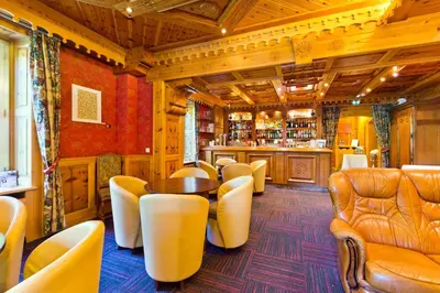 a bar with chairs and a table in a room at Aiguille du Midi - Hôtel & Restaurant in Chamonix-Mont-Blanc