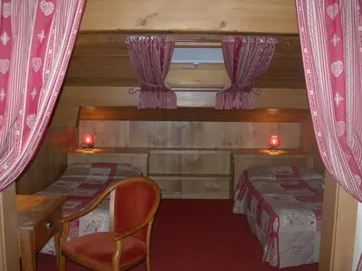 a small room with two beds and a table and a chair at Le Cordonant in Cordon