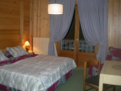 a bedroom with a bed and a table and a window at Le Cordonant in Cordon