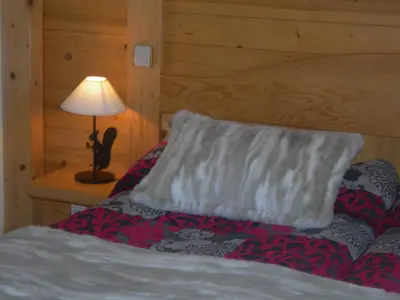 a bedroom with a bed with a pillow and a lamp at Le Cordonant in Cordon