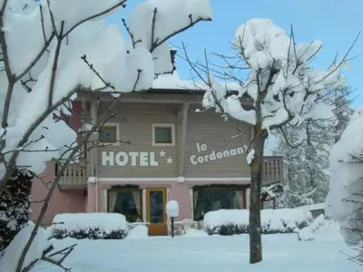 a hotel with snow covered trees in front of it at Le Cordonant in Cordon