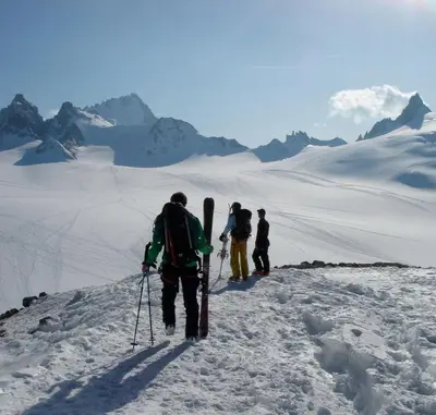 three people walking up a snow covered mountain with skis at Hôtel Val d'Este in Saint-Gervais-les-Bains