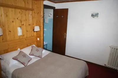 a bedroom with a bed with two pillows on it at Hôtel Val d'Este in Saint-Gervais-les-Bains