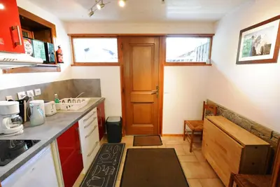 a small kitchen with a sink and a door at Chalet Champraz - Free Parking in Chamonix-Mont-Blanc