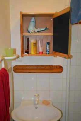 a bathroom with a sink and a shelf above a toilet at Chalet Champraz - Free Parking in Chamonix-Mont-Blanc