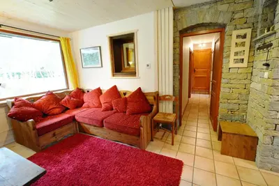 a living room with a red couch and a brick wall at Chalet Champraz - Free Parking in Chamonix-Mont-Blanc