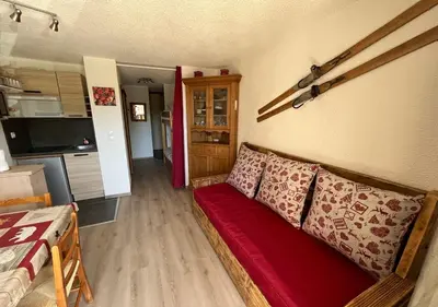 a living room with a red couch in a room at Grand Studio in Les Carroz d'Araches