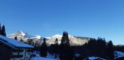a snow covered mountain in the distance with a building at Grand Studio in Les Carroz d'Araches