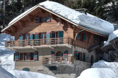 a log cabin with snow on the roof at La Ribambelle in Chamonix-Mont-Blanc