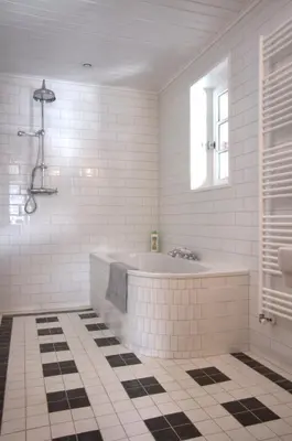a white bathroom with a tub and a window at La Ribambelle in Chamonix-Mont-Blanc
