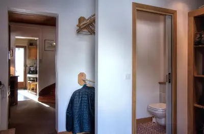 a bathroom with a toilet and a door to a room at La Ribambelle in Chamonix-Mont-Blanc
