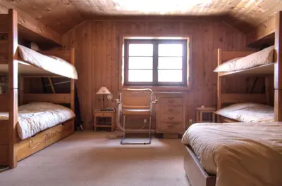 a bedroom with two bunk beds and a window at La Ribambelle in Chamonix-Mont-Blanc