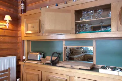 a kitchen with wooden cabinets and a counter with a microwave at La Ribambelle in Chamonix-Mont-Blanc